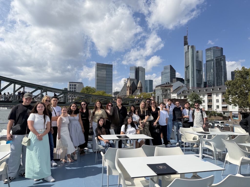 Gruppenfoto der Klasse auf Schifffahrt auf dem Main. Die Skyline Frankfurts im Hintergrund